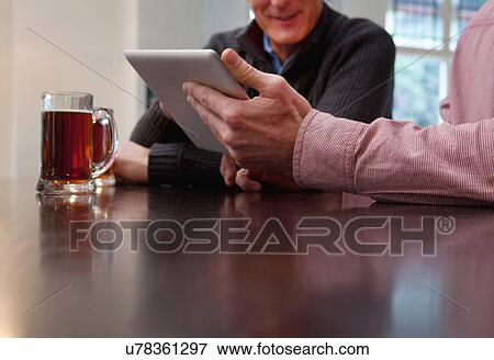 Father and son using digital tablet in bar View Large Photo Image Stock Photo - Father and son using digital tablet in bar. Fotosearch