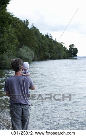 Father holding baby daughter by lake, Starnberg, Germany View Large Photo Image Stock Image - Father holding baby daughter by lake, Starnberg, Germany. Fotosearch