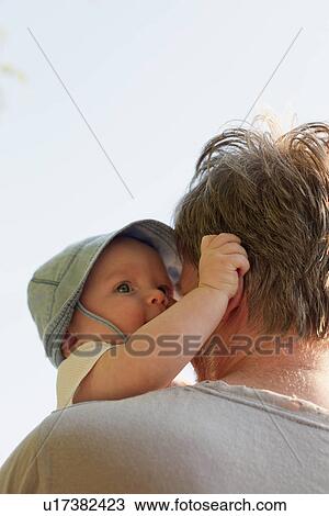 Stock Image - Father holding baby daughter. Fotosearch
