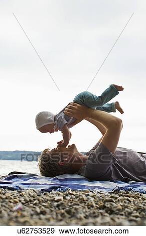 Father lifting baby daughter View Large Photo Image Stock Photo - Father lifting baby daughter. Fotosearch
