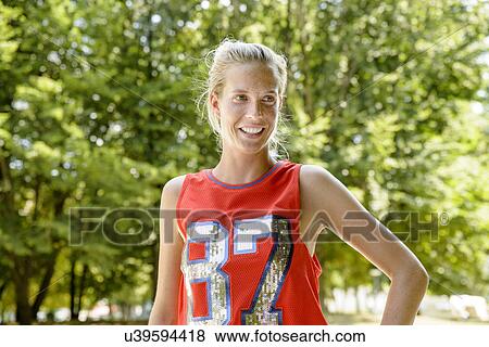 Stock Photo - Female basketball player taking a break in park. Fotosearch