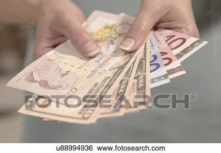 Female hands holding American, British and European currency View Large Photo Image Stock Photograph - Female hands holding American, British and European currency. Fotosearch