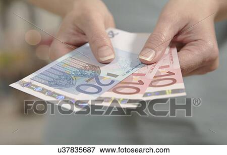 Female hands holding ten and twenty euro notes View Large Photo Image Stock Photo - Female hands holding ten and twenty euro notes. Fotosearch