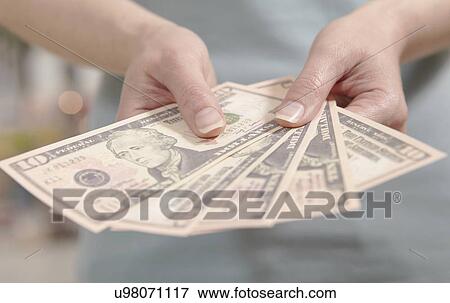Stock Photo - Female hands holding ten dollar notes. Fotosearch
