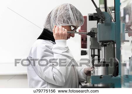 Stock Photograph - Female scientist experimenting in laser laboratory. Fotosearch