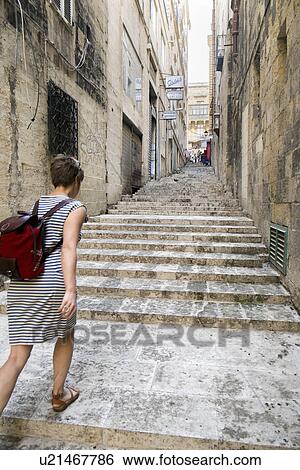 Stock Photograph - Female tourist walking up stairs, Valletta, Malta. Fotosearch