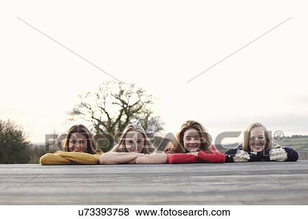 Four teenage girls in a row on patio View Large Photo Image Stock Photo - Four teenage girls in a row on patio. Fotosearch