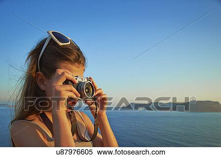 Stock Photography - Girl taking photographs on holiday, Kas, Turkey. Fotosearch
