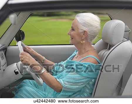 Glamorous senior woman driving in car View Large Photo Image Stock Image - Glamorous senior woman driving in car. Fotosearch