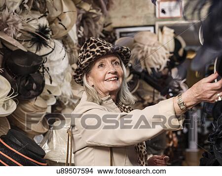 Glamorous senior woman looking at hats View Large Photo Image Picture - Glamorous senior woman looking at hats. Fotosearch