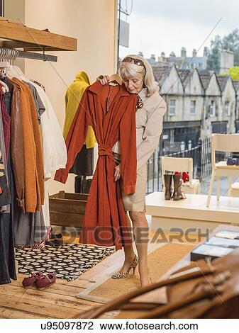 Glamorous senior woman trying dress in boutique View Large Photo Image Stock Image - Glamorous senior woman trying dress in boutique. Fotosearch