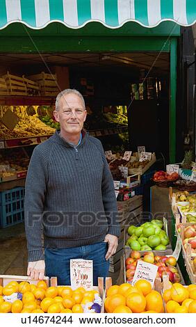 Greengrocer in front of his stall View Large Photo Image Picture - Greengrocer in front of his stall. Fotosearch