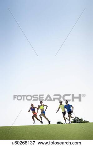 Stock Photo - Group of adult runners running in park. Fotosearch
