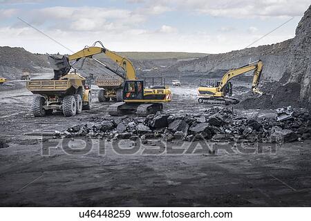 Stock Photo - Machines working in surface coal mine. Fotosearch