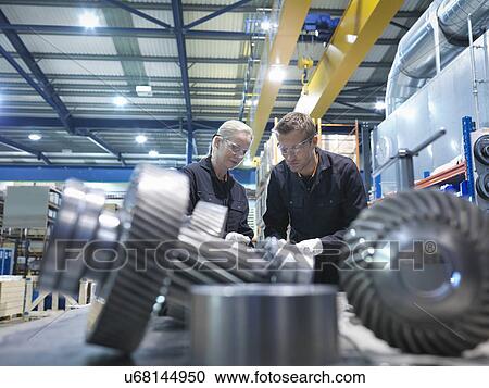 Male and female engineers assembling industrial gearbox in engineering factory View Large Photo Image Stock Image - Male and female engineers assembling industrial gearbox in engineering factory. Fotosearch