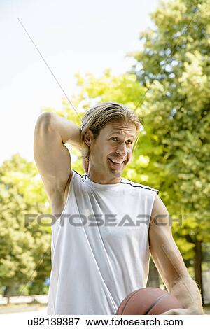 Male basketball player taking a break in park View Large Photo Image Stock Photo - Male basketball player taking a break in park. Fotosearch