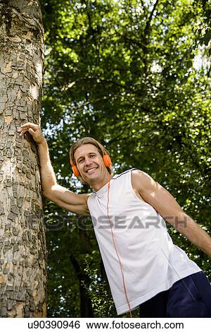 Male runner stretching in woods View Large Photo Image Stock Photograph - Male runner stretching in woods. Fotosearch