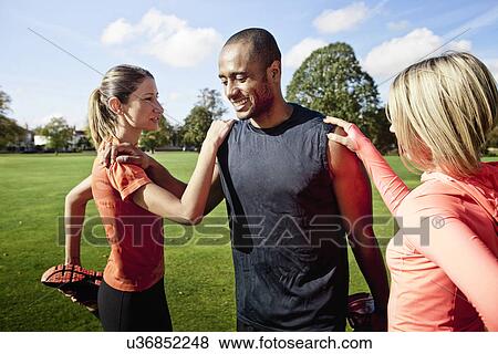 Man and women stretching legs in park View Large Photo Image Stock Photo - Man and women stretching legs in park. Fotosearch