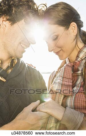 Man holding woman's hand, woman wearing engagement ring View Large Photo Image Stock Image - Man holding woman's hand, woman wearing engagement ring. Fotosearch