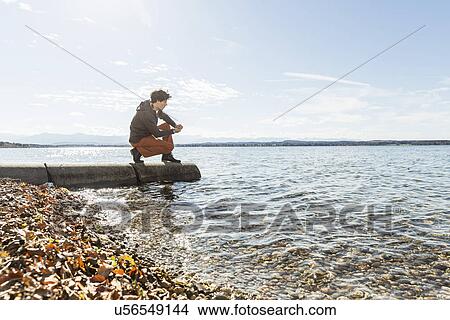 Picture - Man on jetty, Lake Starnberg, Bavaria, Germany. Fotosearch