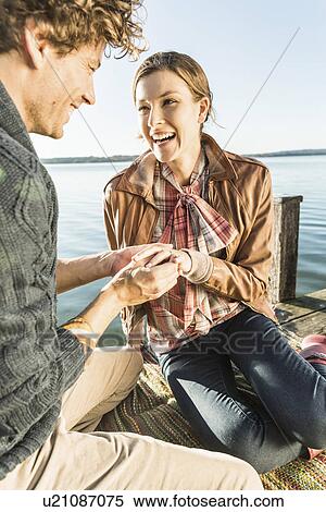 Man putting engagement ring on woman View Large Photo Image Stock Photography - Man putting engagement ring on woman. Fotosearch