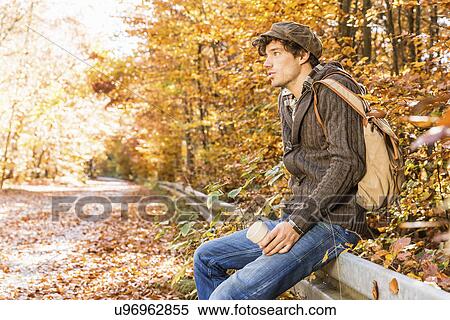 Man sitting on fence in forest View Large Photo Image Stock Photography - Man sitting on fence in forest. Fotosearch