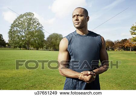 Man standing in park View Large Photo Image Stock Photo - Man standing in park. Fotosearch
