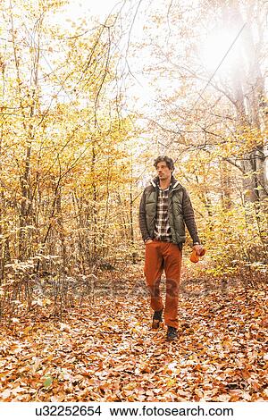 Picture - Man walking in forest in autumn. Fotosearch