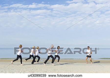Stock Photo - Mature and senior women and trainer running on beach. Fotosearch