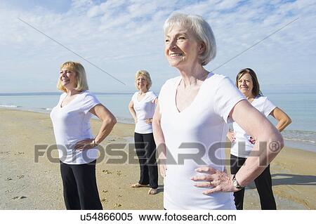 Stock Photography - Mature and senior women exercising on beach. Fotosearch