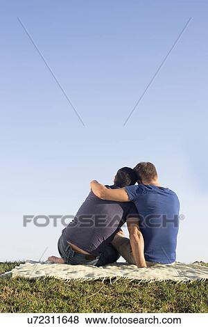 Mature male couple hugging on picnic blanket in park View Large Photo Image Stock Photo - Mature male couple hugging on picnic blanket in park. Fotosearch