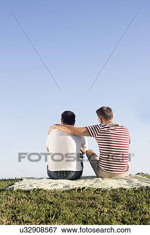 Mature male couple sitting on picnic blanket in park View Large Photo Image Stock Photo - Mature male couple sitting on picnic blanket in park. Fotosearch