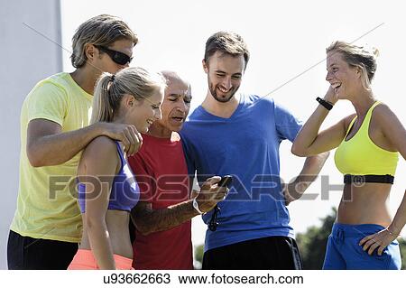 Mature male trainer and a group of adult runners checking stopwatch View Large Photo Image Stock Image - Mature male trainer and a group of adult runners checking stopwatch. Fotosearch