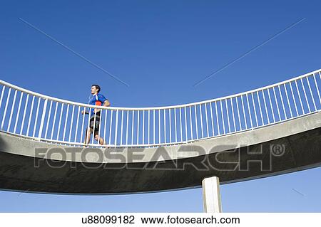 Mature man running on curved footbridge View Large Photo Image Stock Image - Mature man running on curved footbridge. Fotosearch