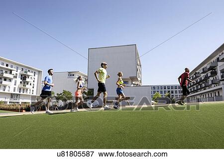 Mature trainer running with small group of adults in park View Large Photo Image Stock Photo - Mature trainer running with small group of adults in park. Fotosearch