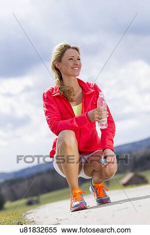 Mid adult woman with bottle of water View Large Photo Image Stock Photography - Mid adult woman with bottle of water. Fotosearch
