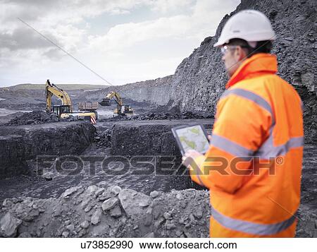 Miner checks plans on digital tablet in surface coal mine View Large Photo Image Stock Image - Miner checks plans on digital tablet in surface coal mine. Fotosearch