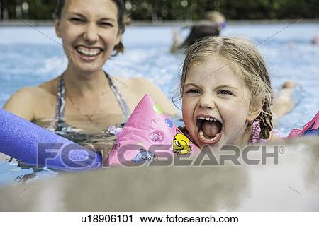 Stock Image - Mother and child having fun in pool. Fotosearch