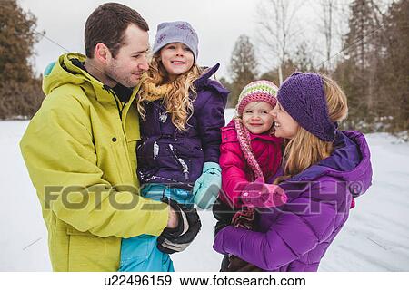 Mother and father carrying daughters in snow View Large Photo Image Stock Photo - Mother and father carrying daughters in snow. Fotosearch
