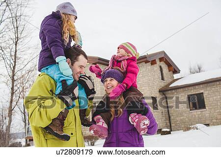 Stock Photo - Mother and father carrying daughters in snow. Fotosearch
