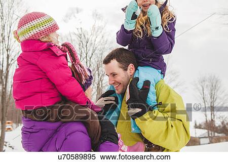 Mother and father carrying daughters in snow View Large Photo Image Stock Photography - Mother and father carrying daughters in snow. Fotosearch