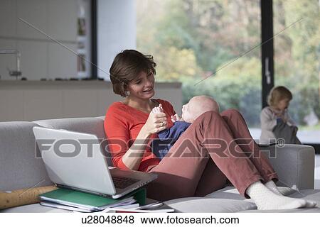 Mother, baby boy and female toddler in sitting room View Large Photo Image Stock Photo - Mother, baby boy and female toddler in sitting room. Fotosearch
