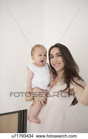 Mother carrying yawning baby View Large Photo Image Picture - Mother carrying yawning baby. Fotosearch