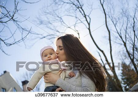 Mother kissing baby in arms View Large Photo Image Stock Photo - Mother kissing baby in arms. Fotosearch
