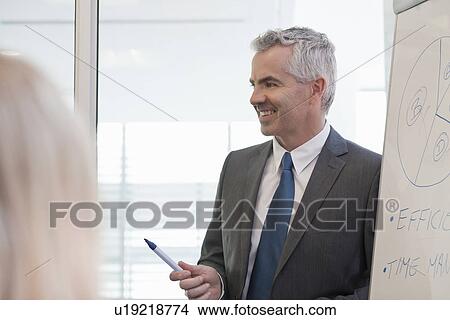 Picture - Office manager giving flipchart presentation. Fotosearch