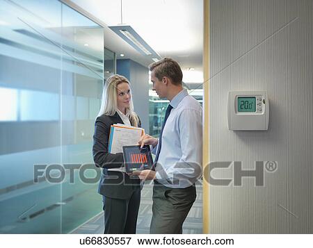 Office workers holding digital tablet and files discussing office energy use View Large Photo Image Stock Photo - Office workers holding digital tablet and files discussing office energy use. Fotosearch