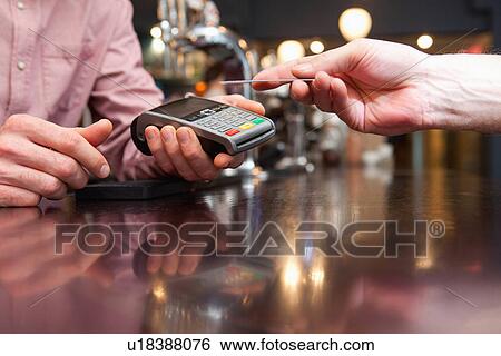 Stock Photograph - Paying bill by credit card. Fotosearch