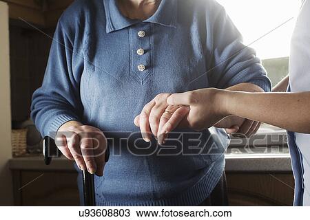 Personal care assistant supporting senior woman to walk View Large Photo Image Stock Image - Personal care assistant supporting senior woman to walk. Fotosearch