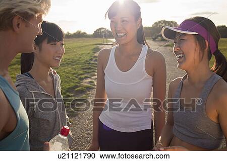 Stock Image - Personal trainer chatting with group of clients. Fotosearch