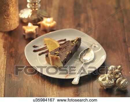 Stock Photo - Pistachio and chocolate torte amongst festive decorations. Fotosearch